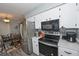 Kitchen with stainless appliances, black microwave, and dark countertops at 881 Cedar Cir, Tavares, FL 32778