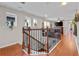 Upstairs hallway featuring an open railing overlooking the living area below, with hardwood floors and modern lighting at 888 Wakulla Ln, Winter Springs, FL 32708