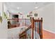 Upstairs hallway featuring an open railing overlooking the living area below, with hardwood floors and modern lighting at 888 Wakulla Ln, Winter Springs, FL 32708