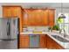 Bright kitchen featuring stainless appliances, wood cabinetry, and granite countertops with stainless sink at 888 Wakulla Ln, Winter Springs, FL 32708