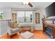 Cozy living room featuring a comfortable chair, ottoman, fireplace, and a large window with a bench at 888 Wakulla Ln, Winter Springs, FL 32708