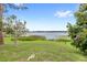 Expansive backyard with mature trees and serene lake views at 942 Beach Breeze Dr, Orlando, FL 32835