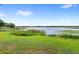 Expansive backyard with lush green lawn and waterfront access to a scenic lake at 942 Beach Breeze Dr, Orlando, FL 32835