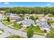 Aerial neighborhood view showing a light green home, lush landscaping, and nearby trees at 1028 Ocala Woods Ln, Orlando, FL 32824