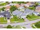 Low-altitude aerial view showcasing the light green home, manicured lawn, and surrounding neighborhood at 1028 Ocala Woods Ln, Orlando, FL 32824