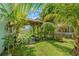 Lush backyard oasis featuring tropical plants, greenery and pergola at 1028 Ocala Woods Ln, Orlando, FL 32824