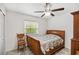 Bedroom with wood bed frame, ceiling fan, and neutral walls at 1028 Ocala Woods Ln, Orlando, FL 32824