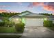 Charming single-story home showcasing a lush green lawn, mature shrubs, and a two-car garage, radiating curb appeal at 1028 Ocala Woods Ln, Orlando, FL 32824