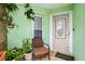 Cozy front porch with plants, chair, and a secure front door with storm door to greet visitors at 1028 Ocala Woods Ln, Orlando, FL 32824