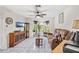 Bright living room boasts tiled flooring, a ceiling fan, a large window and comfortable seating, perfect for relaxation at 1028 Ocala Woods Ln, Orlando, FL 32824