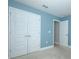 Light blue bedroom featuring neutral carpet and double door closet at 1061 Citrus Landings Blvd, Davenport, FL 33837
