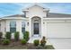 Close-up of the front door with a black door, landscaping and two coach lights at 1061 Citrus Landings Blvd, Davenport, FL 33837
