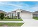 Charming single-story home featuring a two-car garage, well-maintained lawn, and inviting front entrance at 1061 Citrus Landings Blvd, Davenport, FL 33837