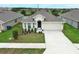 Charming one-story home featuring a well-manicured lawn, small shrubs, and a two-car garage at 1061 Citrus Landings Blvd, Davenport, FL 33837