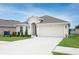 Charming one-story home with manicured lawn, two car garage, and beige exterior at 1061 Citrus Landings Blvd, Davenport, FL 33837