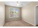 Bedroom features neutral walls, carpet, a ceiling fan and a window overlooking a yard with mature trees at 1101 Vintage Village Ln # 101, Ocoee, FL 34761