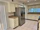 Well-lit kitchen showcasing cabinets, stainless steel refrigerator, and tiled floor at 1110 Woodbine Street, Fern Park, FL 32730