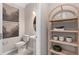 A stylish powder room is equipped with shelving for storage and decorative art at 11429 Nona Sound St, Orlando, FL 32832