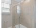 A bathroom has tile floors, a shower with a glass door, and a window at 11429 Nona Sound St, Orlando, FL 32832