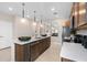 Modern kitchen features an island with a sink and stainless steel appliances and hardware at 11429 Nona Sound St, Orlando, FL 32832