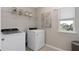 Functional laundry room with modern appliances, storage shelves, and natural light at 11429 Nona Sound St, Orlando, FL 32832