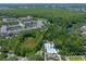 Aerial view of condos, a lake, and a pool, surrounded by a lush forest and nearby shops at 1200 Ironsmith Dr # 508, Celebration, FL 34747