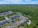 Aerial shot of condos with a lake, surrounded by tall green trees, near retail shops at 1200 Ironsmith Dr # 508, Celebration, FL 34747