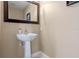 White pedestal sink with a framed mirror in a bathroom featuring neutral paint and tile at 1200 Ironsmith Dr # 508, Celebration, FL 34747
