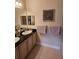 Bright bathroom featuring a double sink vanity with dark countertops and tiled floors at 1200 Ironsmith Dr # 508, Celebration, FL 34747
