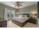 Bedroom with green walls, ceiling fan, and large windows offering natural light and tree views at 1200 Ironsmith Dr # 508, Celebration, FL 34747