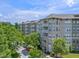 Exterior shot of condos with white balconies, set among mature trees, sidewalks, and manicured landscaping at 1200 Ironsmith Dr # 508, Celebration, FL 34747