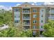 Exterior view of the building featuring multiple balconies and inviting facade, surrounded by lush trees at 1200 Ironsmith Dr # 508, Celebration, FL 34747