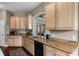 Kitchen with granite countertops, tan cabinets, stainless steel appliances, and a stone archway at 1200 Ironsmith Dr # 508, Celebration, FL 34747