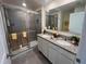 Bathroom with double sinks, granite countertop, and glass-enclosed shower with tile at 12035 Holystone St, Winter Garden, FL 34787