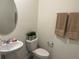 Cozy half bathroom featuring a modern sink, toilet, and decorative towels at 12035 Holystone St, Winter Garden, FL 34787