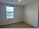 A sunlit bedroom features a window and neutral carpeting at 12035 Holystone St, Winter Garden, FL 34787