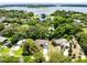 Aerial view showcases the property nestled among lush greenery and trees, with a glimpse of the lake in the background at 13018 S Sunset Ter, Winter Garden, FL 34787