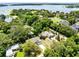 Beautiful aerial view of the property near a scenic lake surrounded by mature trees and neighboring homes at 13018 S Sunset Ter, Winter Garden, FL 34787