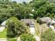 An aerial shot shows a cozy home nestled among green trees, with neighboring houses and a glimpse of the lake at 13018 S Sunset Ter, Winter Garden, FL 34787