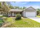 Charming gray home with a two car garage, covered porch, and well maintained front yard at 13018 S Sunset Ter, Winter Garden, FL 34787