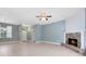 Bright living room featuring a brick fireplace, ceiling fan, and neutral tile flooring at 13018 S Sunset Ter, Winter Garden, FL 34787