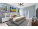 Staged main bedroom featuring laminated floors, neutral paint, windows, ceiling fan, and tasteful decor at 13018 S Sunset Ter, Winter Garden, FL 34787