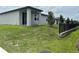 View of the backyard, featuring a well-maintained lawn, young trees, and a partial view of neighboring homes at 1345 Griffon Ave, Lake Alfred, FL 33850