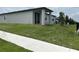 A view of the backyard with a manicured lawn, young trees, and a partial view of neighboring homes at 1345 Griffon Ave, Lake Alfred, FL 33850