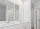 Elegant bathroom with double sinks, white cabinets, and modern fixtures, next to a shower at 1345 Griffon Ave, Lake Alfred, FL 33850