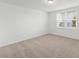 Clean, carpeted bedroom illuminated by natural light streaming through a window at 1345 Griffon Ave, Lake Alfred, FL 33850