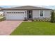 Charming single-Gathering home with a well-manicured lawn, a brick driveway and a two-car garage at 1345 Griffon Ave, Lake Alfred, FL 33850