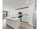 Modern white kitchen features stainless appliances, an island, and access to an outdoor patio at 1345 Griffon Ave, Lake Alfred, FL 33850