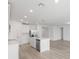 Open kitchen with a center island, stainless steel appliances, light wood floors, and access to the living area at 1345 Griffon Ave, Lake Alfred, FL 33850