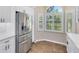 Eat-in kitchen area with stainless steel refrigerator, white cabinets, and a view of the landscaped backyard at 139 Andrews Rd, Sanford, FL 32773